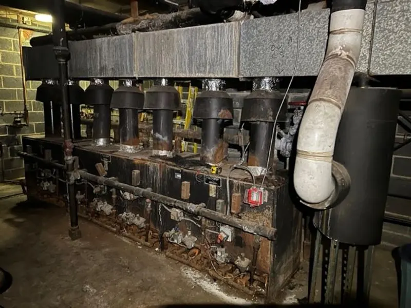 Gas and venting pipework running along an apartment building exterior.