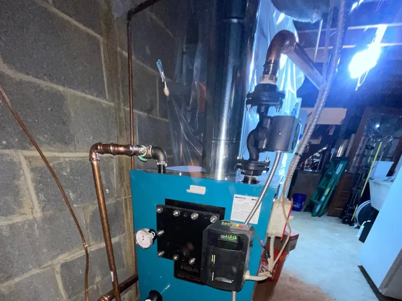 A blue commercial packaged HVAC unit installed in a building service alley.