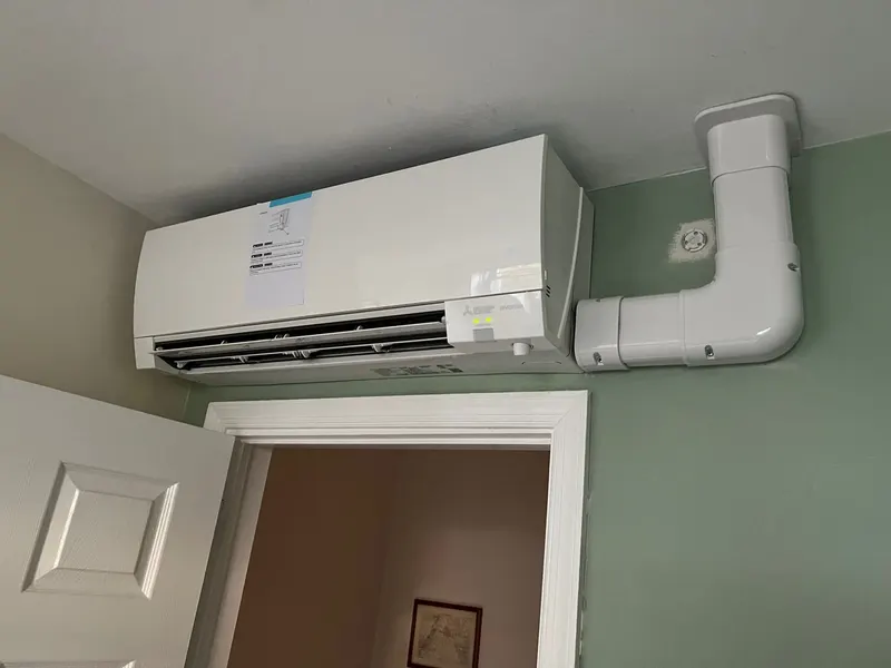 A ductless mini-split indoor air handler mounted high on an interior wall.