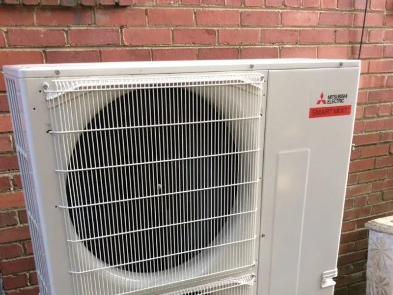 Stacked outdoor condensing units installed at a residence.