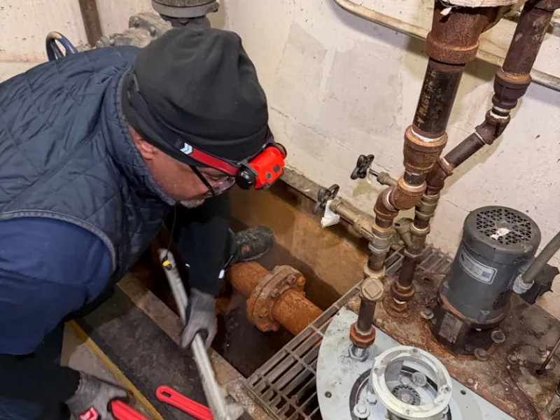 Logan Mechanical technician servicing commercial boiler and pump piping